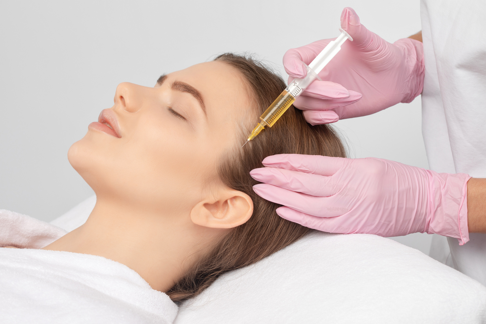 Cosmetologist does prp therapy against hair loss and anti-dandruff of a beautiful woman in a beauty salon. Aesthetic cosmetology concept, hair treatment.